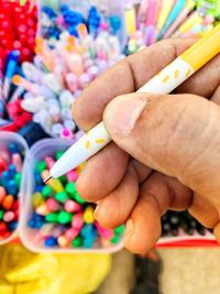 Close-up of hand holding multi colored candies