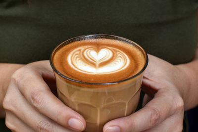 Midsection of woman holding coffee cup