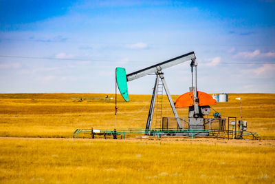 Traditional windmill on field against sky