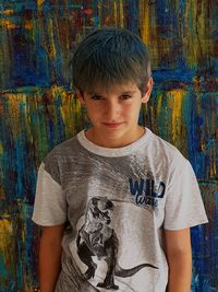 Portrait of boy standing against wall