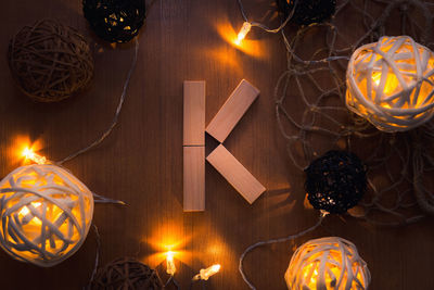 Directly above shot of letter k blocks and illuminated lights on wooden table