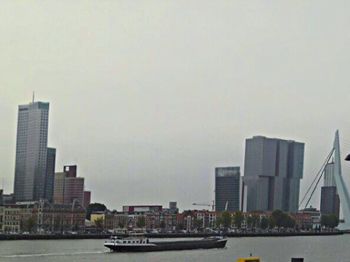 Boats in river with city in background