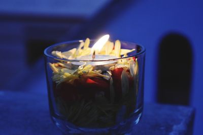 Close-up of lit candle on table