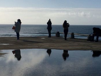 Silhouette of people standing on beach