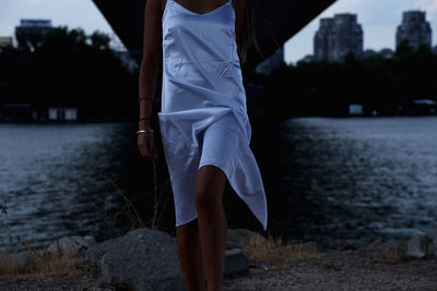 Rear view of woman standing by lake