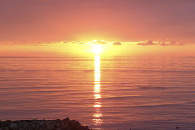 Scenic view of sea against romantic sky at sunset