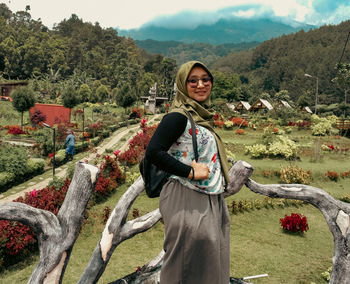 Portrait of young woman standing on field