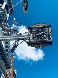 Low angle view of clock tower against blue sky