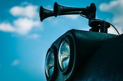 Close-up of vintage car against blue sky