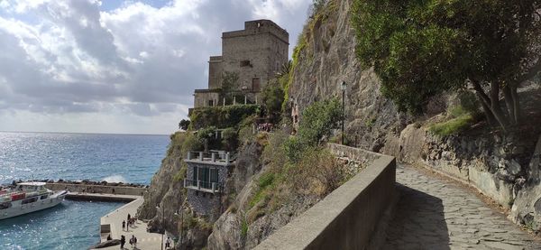 Buildings by sea against sky