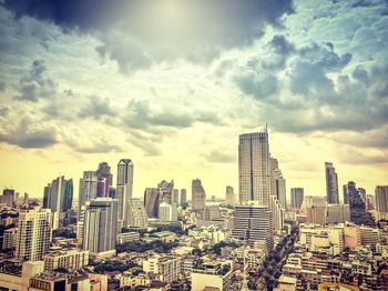 View of cityscape against cloudy sky