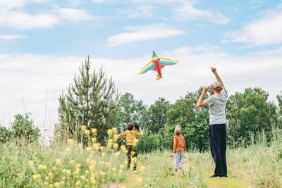 Dad and sons let a kite in the street. happy childhood with dad. active games on the street. 