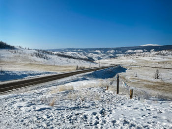 Scenic view of snow covered landscape against blue sky