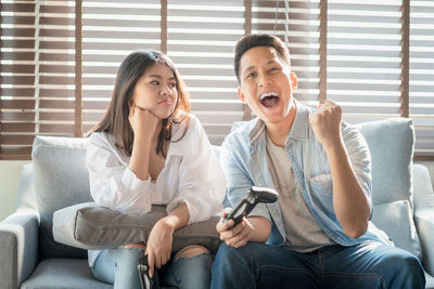 Young couple sitting on sofa at home