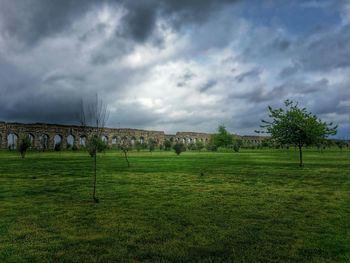 Scenic view of grassy field against cloudy sky