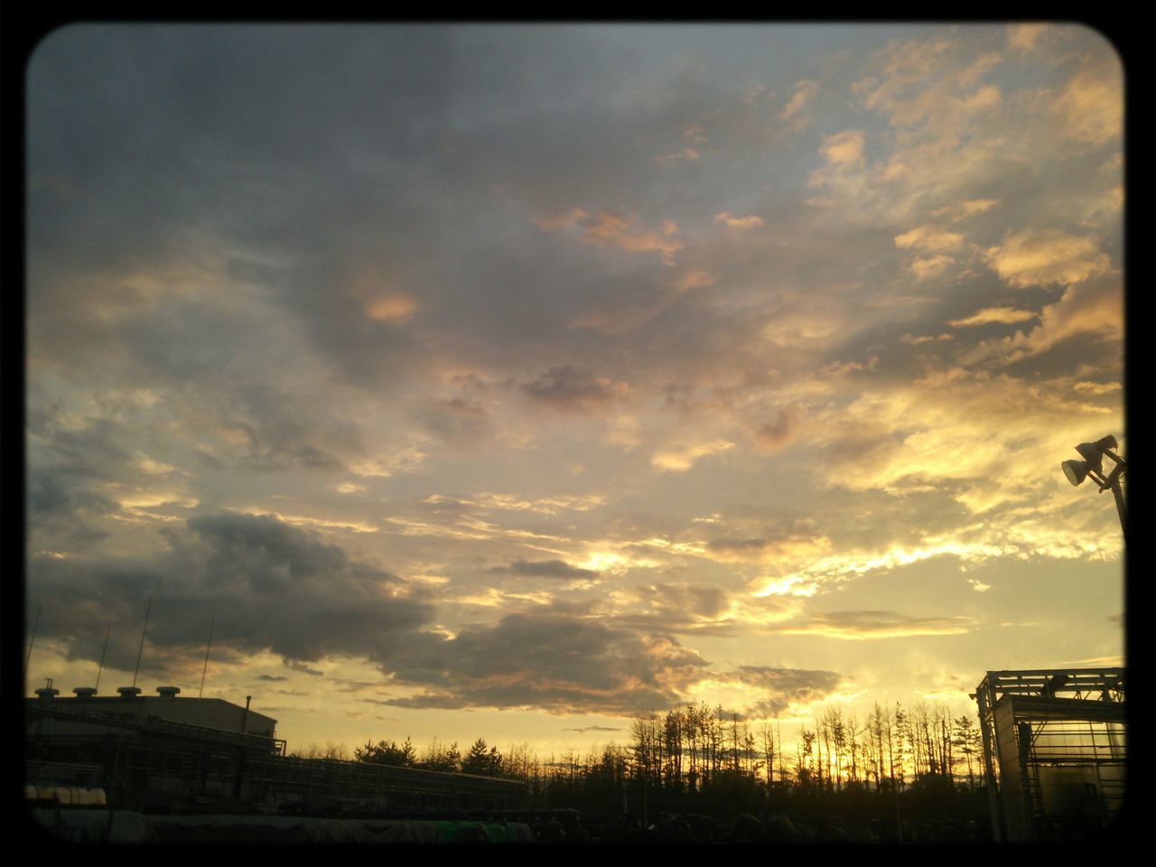 transfer print, sunset, sky, cloud - sky, silhouette, auto post production filter, beauty in nature, scenics, cloudy, tree, tranquility, tranquil scene, cloud, nature, dramatic sky, built structure, landscape, low angle view, orange color, building exterior