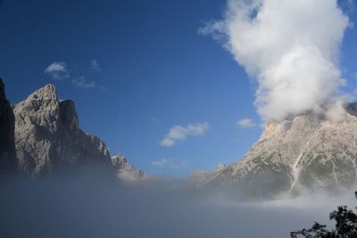 Low angle view of snowcapped mountains against sky