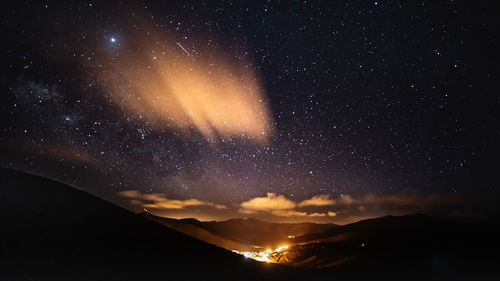 Scenic view of mountains against sky at night