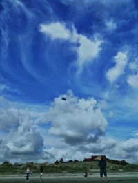 Flying kite on beach against blue sky