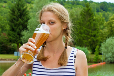 Close-up of young woman drinking beer