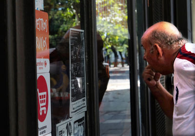 Portrait of man with text on glass window