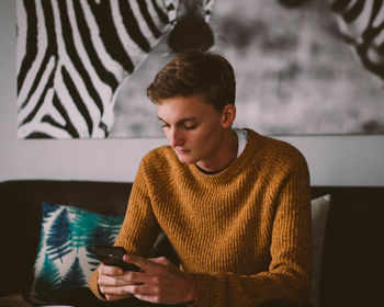 Young man using mobile phone at home