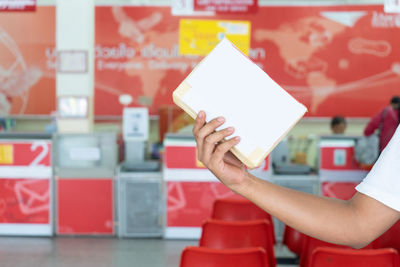 Midsection of man holding paper with text