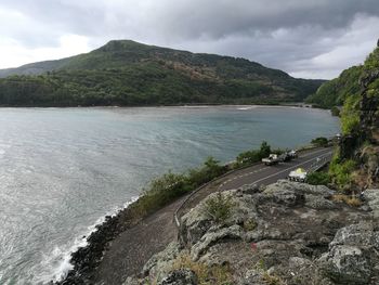 Scenic view of road by sea against sky