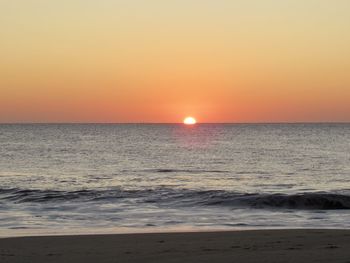 Scenic view of sea against orange sky