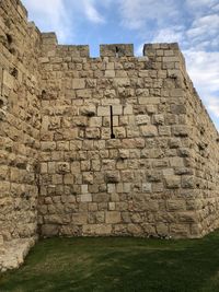 Low angle view of stone wall against sky
