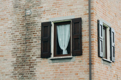 Low angle view of window on brick wall