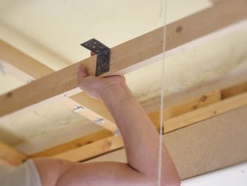 Cropped hand of carpenter working over ceiling at home