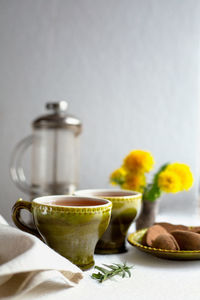 Spring still life with dandelion tea and sweets in yellow-green tones