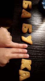 Close-up of hand holding bread on table