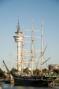 Sailboats moored on sea against clear sky