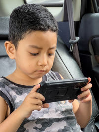 Close-up of boy holding mobile phone 