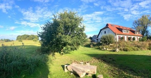 Scenic view of agricultural field by houses against sky