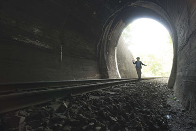 Rear view of man standing in tunnel