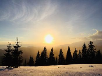 Scenic view of snow covered landscape against sky during sunset