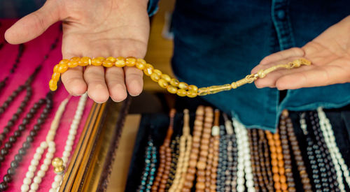 Midsection of person holding prayer beads