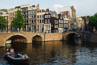 Bridge over river by buildings in city