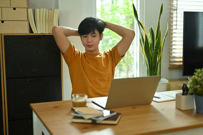 Young man looking at laptop while sitting at home