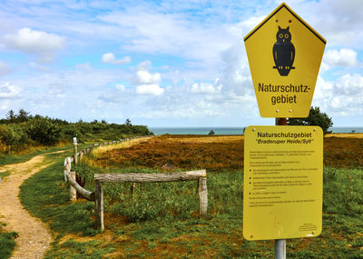 Information sign on land against sky