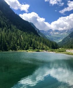 Scenic view of lake by mountains against sky
