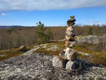 Stack of rocks on land against sky