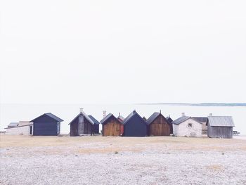 Huts on beach against clear sky