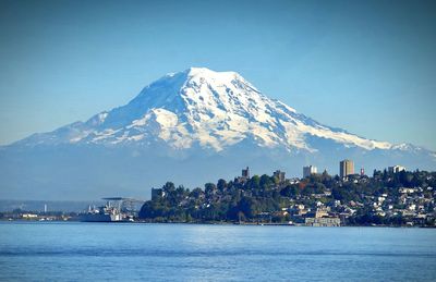 Scenic view of sea and snowcapped mountain against sky