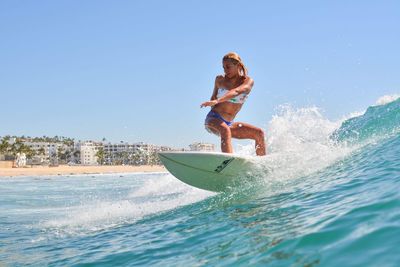 Man surfing on sea against clear sky