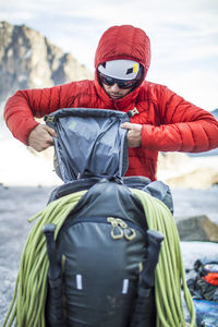 Backpacker packing up his backpack during climbing trip.