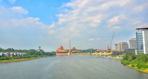 View of river by buildings against sky